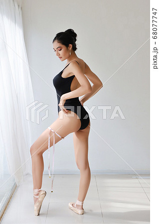 full length healthy and slim woman taking measurements of her body 68077747