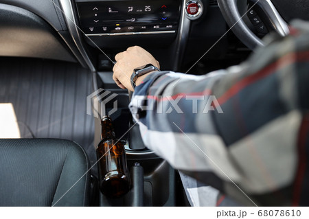 man hands driving car with alcohol bottle beside man hands driving car with alcohol bottle beside 68078610