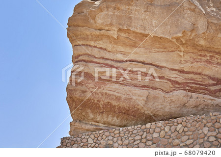Rock with a soil layers against blue sky 68079420