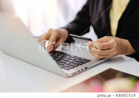 Woman hand holding credit card and using laptop computer on table for online payment shopping online Woman hand holding credit card and using laptop computer on table for online payment shopping online 68082319