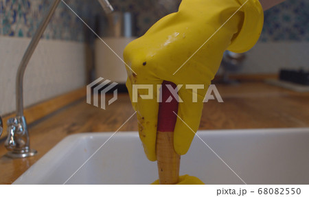 Female hands cleaning a blockage in a kitchen sink 68082550