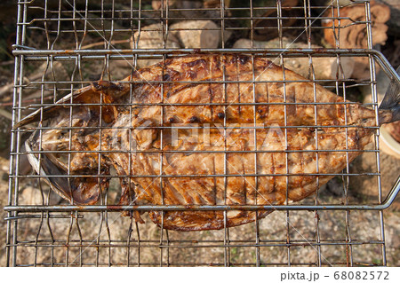 Fresh fish with sauce cooked on an open flame 68082572