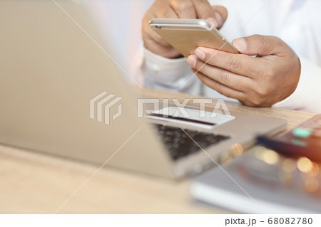 Man hands standing and using calculator and laptop computer on table for online payment shopping 68082780
