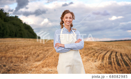 Woman farmer apron standing farmland smiling Woman farmer apron standing farmland smiling 68082985