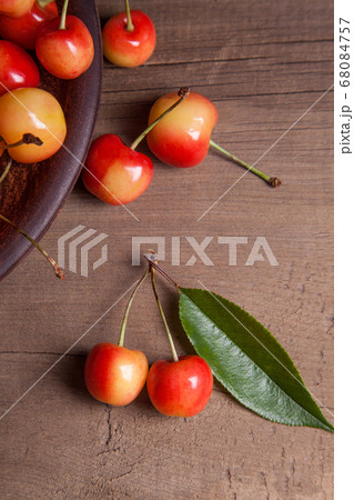 Clay plate with yellow sweet cherry on wooden 68084757