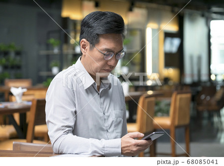 Chinese businessman looking at his cellphone in 68085041