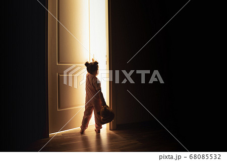 Little girl opens the door to the light in darkness 68085532
