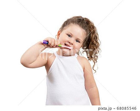 Cute blond girl brushing her teeth on isolated white background. 68085546