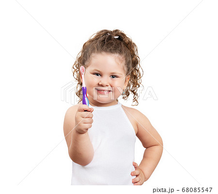Cute blond girl brushing her teeth on isolated white background. 68085547