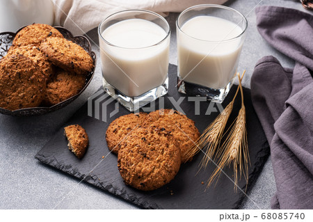 Homemade cookies cereals oats and a glass of milk on the grey concrete table. 68085740