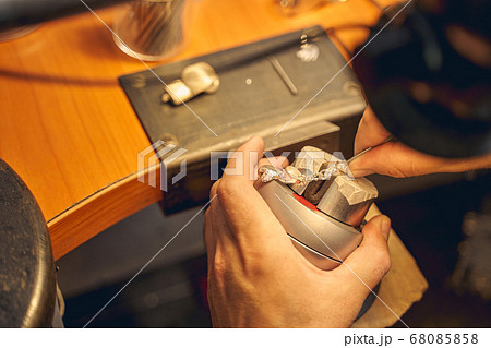 Skilled craftsman treating a new jewelry item 68085858