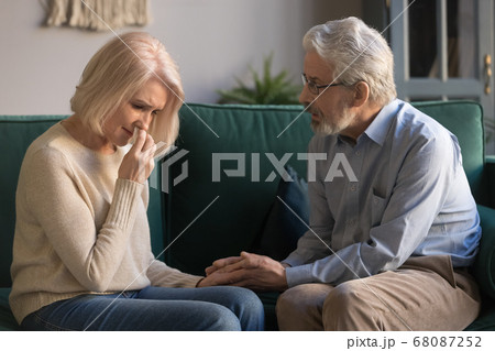 Loving kind old husband consoling comforting sad crying grieving wife 68087252