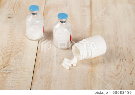 Various pill bottles and different pills on wooden table Various pill bottles and different pills on wooden table 68088459