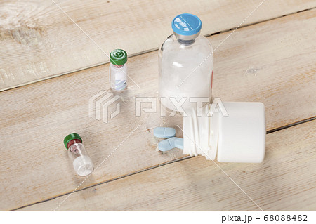 Various pill bottles and different pills on wooden table 68088482