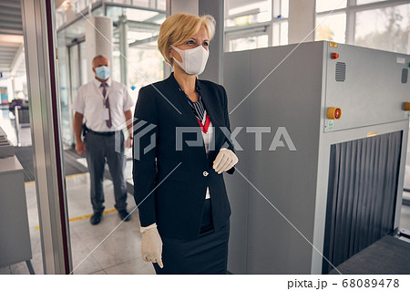 Charming woman walking through security control gate at airport 68089478