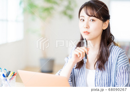 リビングでリモートワーク中の若い女性。 68090267