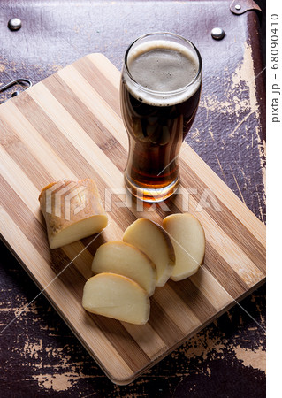 Glass with dark beer with smoked cheese on cutting 68090410