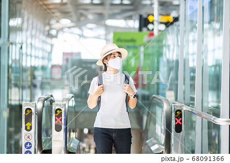 Young adult female wearing face mask in airport 68091366