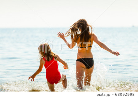 Little girl kid and woman mother in sea water. Fun Little girl kid and woman mother in sea water. Fun 68092998