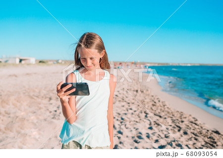Adorable little girl at beach during summer vacation Adorable little girl at beach during summer vacation 68093054
