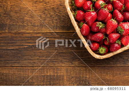 Fresh strawberries in basket on a wooden table Fresh strawberries in basket on a wooden table 68095311