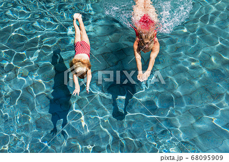 Child with mother dive underwater in swimming pool 68095909