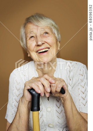 Senior Woman Relaxing In Chair Holding Walking 68096392
