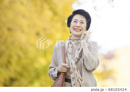 野外で電話するシニア女性 68103424