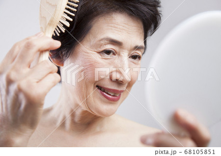 髪の毛をとかすシニア女性 髪の毛をとかすシニア女性 68105851