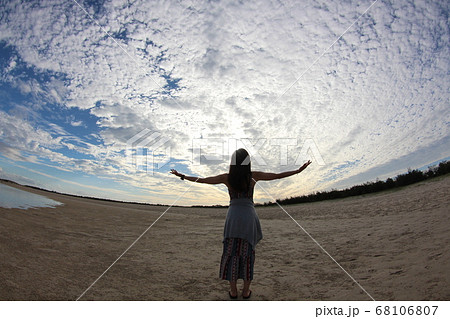 手を広げて空を見る女性 68106807