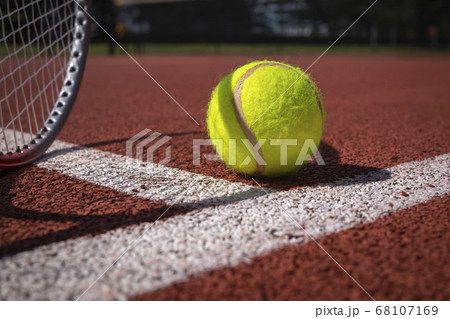 Tennis ball, racket and line on an outdoor court Tennis ball, racket and line on an outdoor court 68107169
