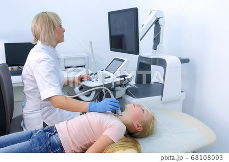 Doctor examining patient child girl thyroid gland using ultrasound scanner. Doctor examining patient child girl thyroid gland using ultrasound scanner. 68108093