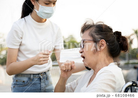 Asian granddaughter is care,help for senior grandmother,old people suffering from cough,child girl and elderly wearing medical mask because of air pollution,outbreak of Covid-19,spread of Coronavirus Asian granddaughter is care,help for senior grandmother,old people suffering from cough,child girl and elderly wearing medical mask because of air pollution,outbreak of Covid-19,spread of Coronavirus 68108466