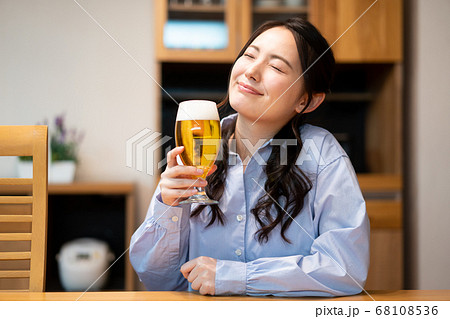 若い女性、部屋でビールを飲む 68108536