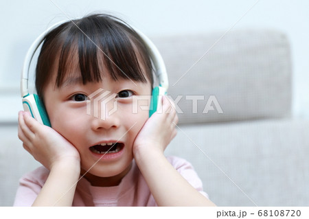 ヘッドフォンで音楽を聴きながら歌う女の子 68108720