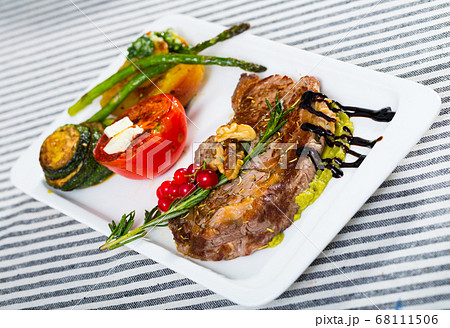 Grilled veal loin with guacamole and baked vegetables 68111506
