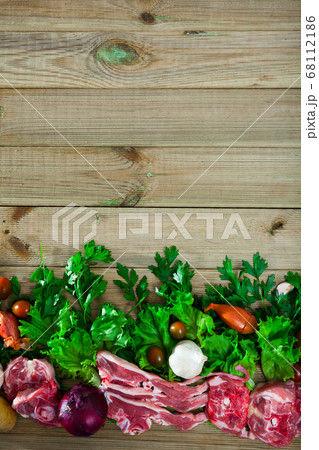 Raw mutton and vegetables assortment on natural wooden background Raw mutton and vegetables assortment on natural wooden background 68112186