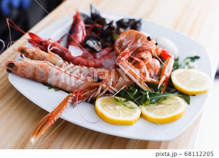 Plate with cooked shrimps, langoustines, clams Plate with cooked shrimps, langoustines, clams 68112205