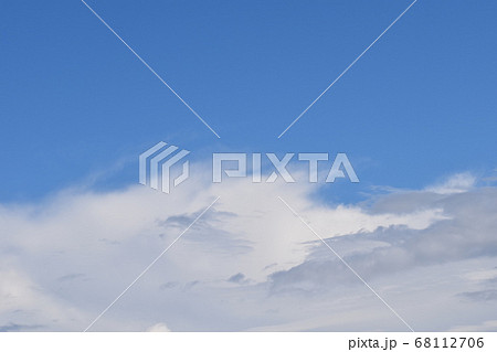 青空に浮かぶ白雲と黒雲の競演の写真素材