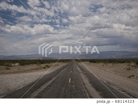 Thick clouds over badly asphalted road 68114323