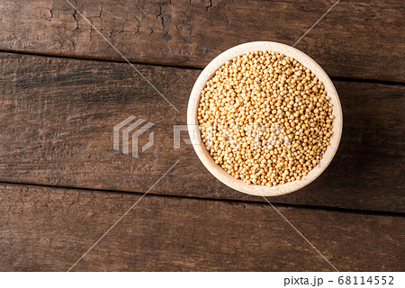 White mustard seeds in bowl on wooden table. Close up. Top view 68114552