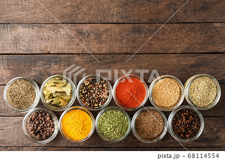 Colourful spices in bowls on wooden table with copyspace. Big collection of spices. Top view 68114554