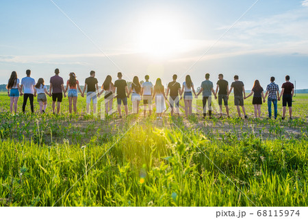Cohesion concept. A group of friends are holding hands at sunset. Cohesion concept. A group of friends are holding hands at sunset. 68115974