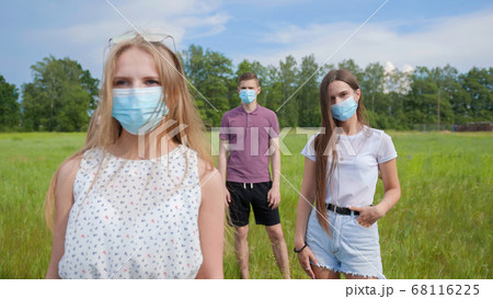 Pandemic concept. A group of students stand in a row in masks. Pandemic concept. A group of students stand in a row in masks. 68116225
