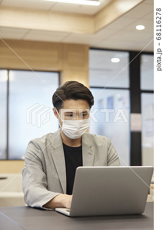 マスクをしてオフィスで働く男性 68116278