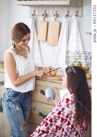 Mother making tea for her ailing daughter 68117201