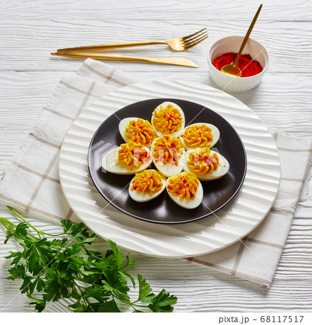 Devilled eggs with sriracha sauce on a black plate 68117517