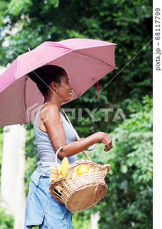 young woman with an umbrella and holding a basket. young woman with an umbrella and holding a basket. 68117799