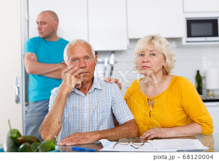 Upset mature parents discussing after quarrel with son Upset mature parents discussing after quarrel with son 68120004