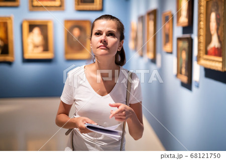 Young woman looking at artworks in museum Young woman looking at artworks in museum 68121750